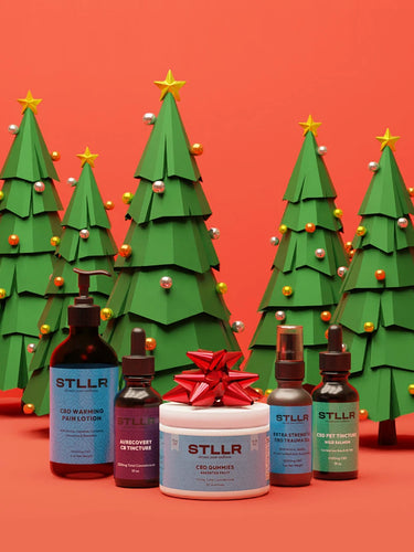 STLLR CBD products with decorative Christmas trees on a red background